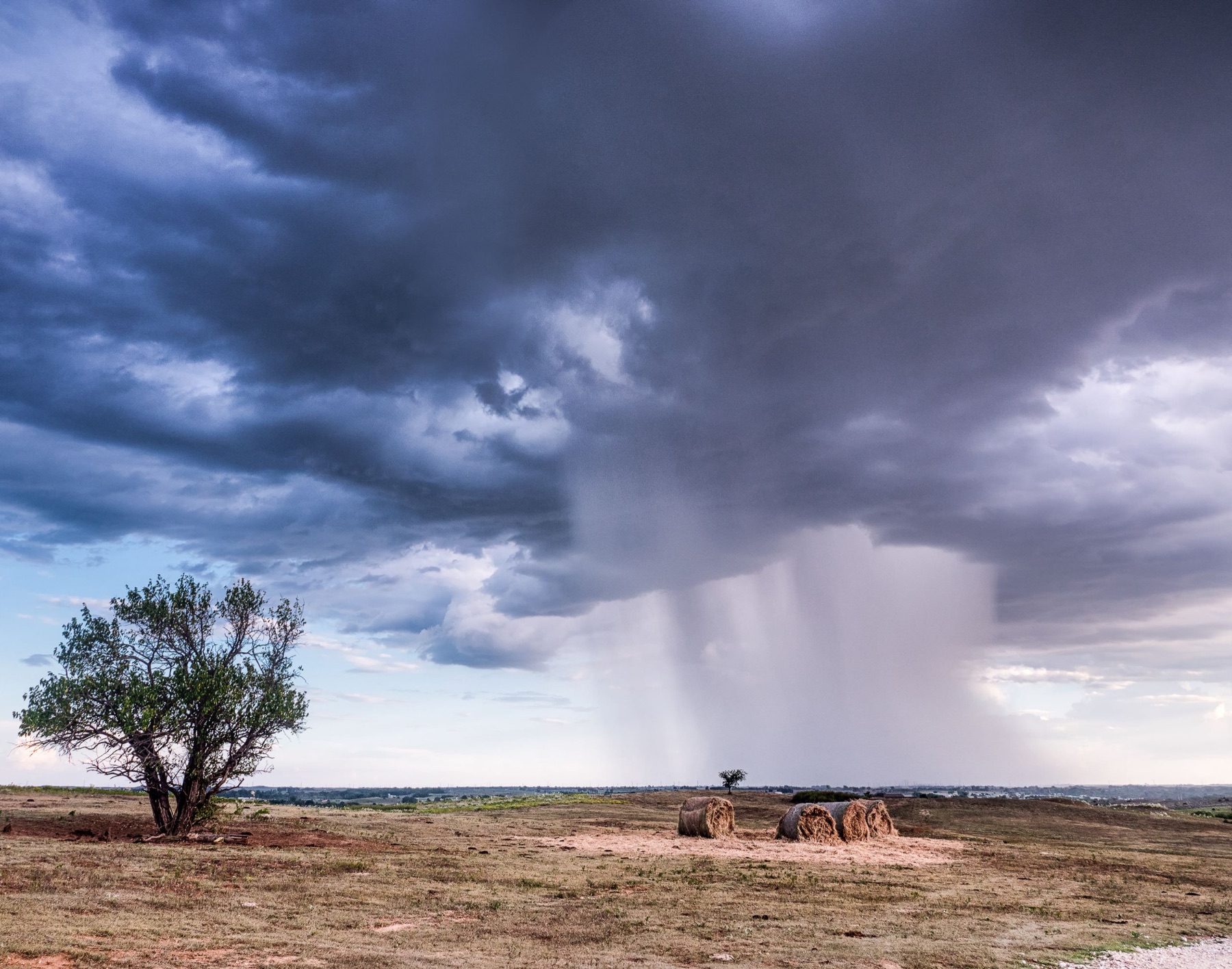 A rain shaft over hay ground on the Oklahoma plains, Oklahoma